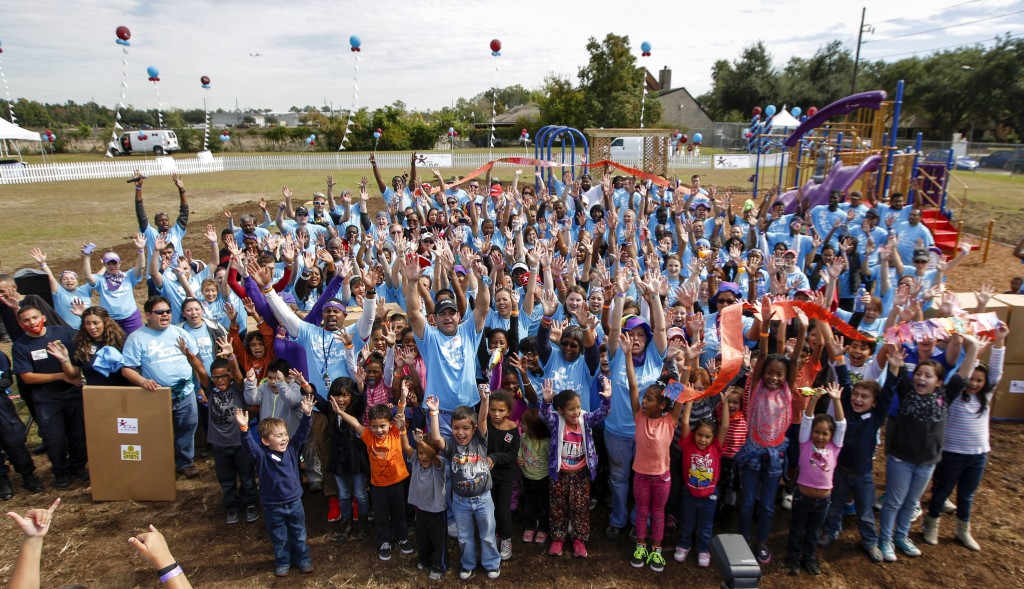 More than 200 volunteers celebrate after building a new playground at Calvert Elementary School on Saturday, Nov. 8, 2014, in Houston. The volunteers also distributed more than $50,000 in sports equipment to various Houston-area schools and youth programs. The projects were made possible by Let's Play, a community partnership led by Dr Pepper Snapple Group to encourage kids and families to get active, with partner organizations KaBOOM! and Good Sports. (Photo by Eric Kayne/Invision for Dr Pepper Snapple Group/AP Images)